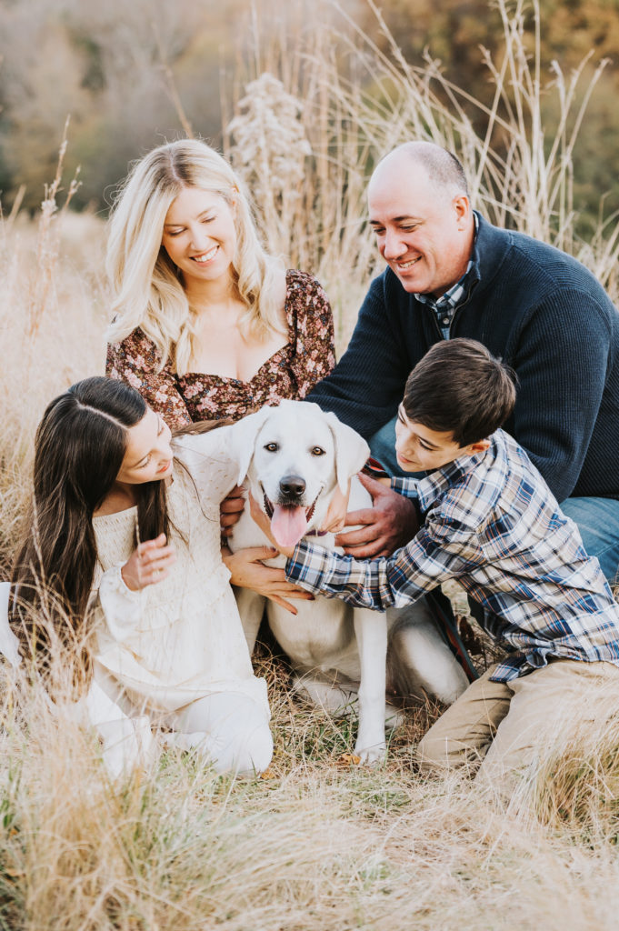 Family pets and smiles at their dog during family photo session with Worth Capturing in Raleigh, NC