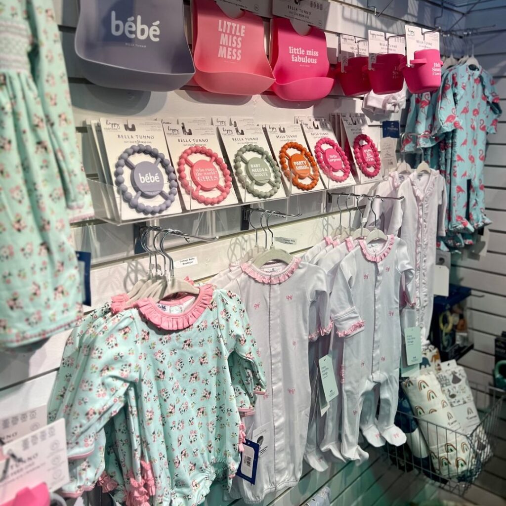 Merchandise display of clothing and baby accessories at Cottage Baby Boutique in Raleigh, NC.