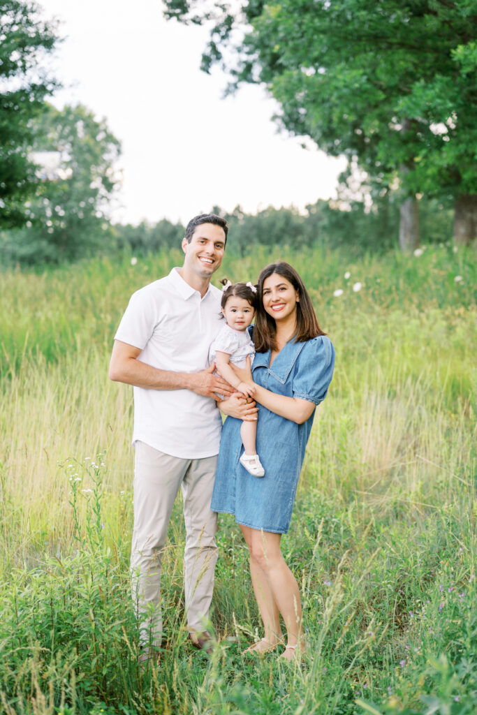 Family smiles at camera during Raleigh family photographer NC Museum of Art Park